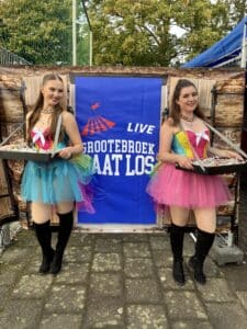 Twee dames in feestelijke kleding met een dienblad vol flugels